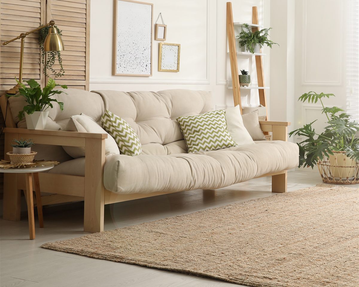 A cream sofa and plants in a softly lit sitting room.
