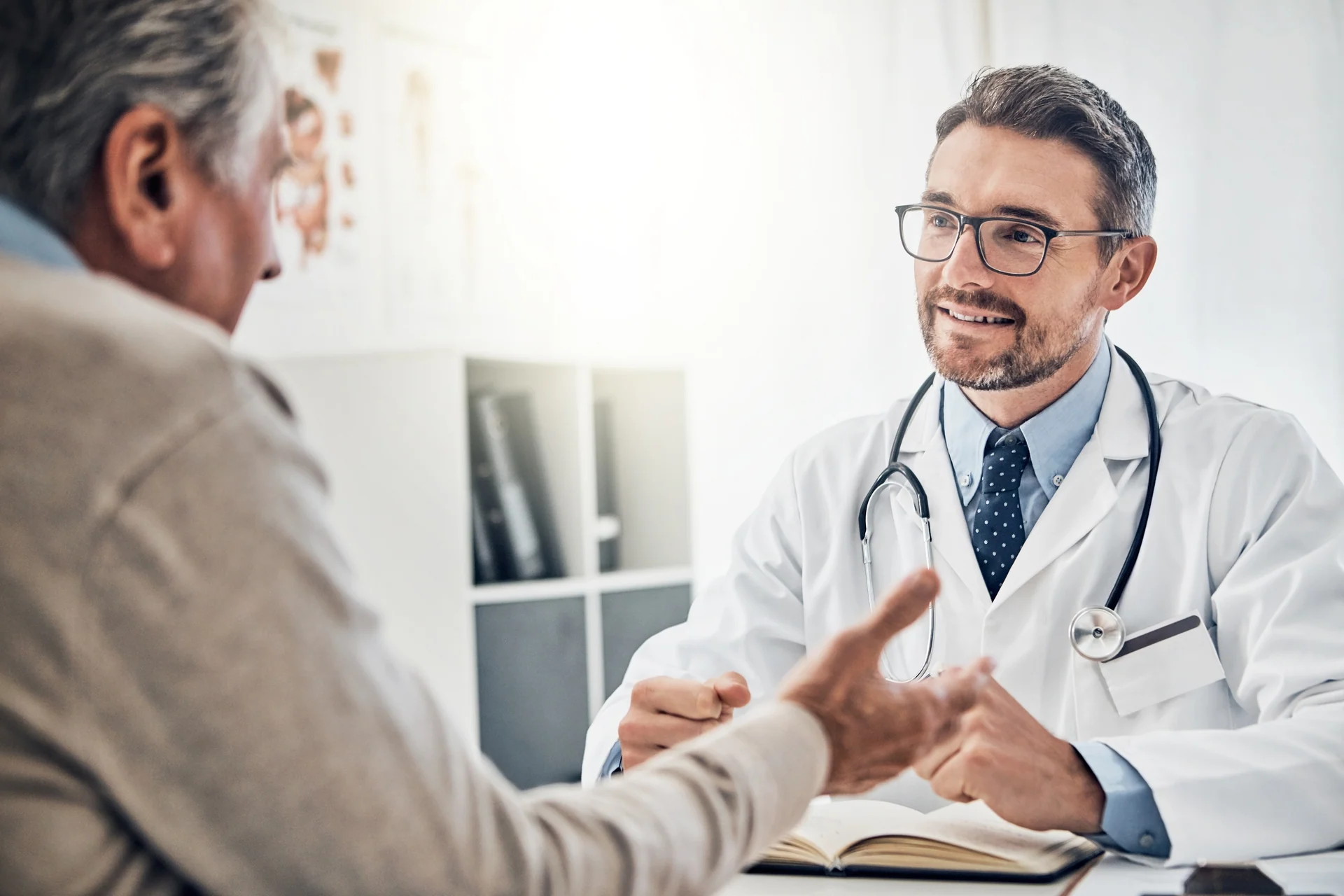 A physician listens while a patient explains a concern.